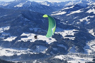 Paraglider flies from the Hohe Salve into the valley of Hopfgarten
