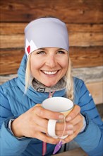 Female skier at the tea break at the hut