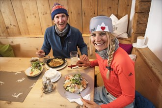 Skiers having lunch in a hut