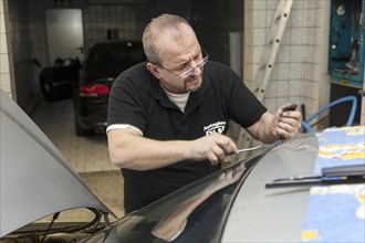 Changing the windscreen of a car in a garage for car glass
