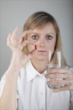 Young woman taking a capsule