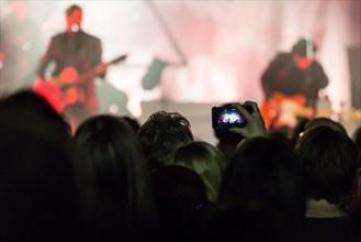 Concertgoer takes a photo with I Phone at the concert of the Swiss band 77 Bombay Street live at Schuur Lucerne