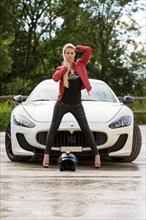 Young woman with long blond hair poses with white Maserati Gran Turismo MC Stradale