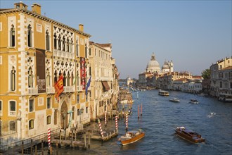 Water taxis and vaporetto on Grand Canal with Renaissance architectural style palace buildings in San Marco and Santa Maria della Salute basilica in Dorsoduro