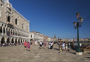 Tourists on Riva degli Schiavoni promenade in front of the Doge's Palace