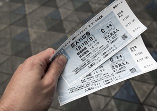 Fan holds tickets to a baseball game at Tokyo Dome