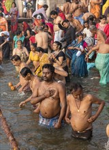 Hindu worshippers perform ritual bath and puja prayers at ghats in the River Ganges