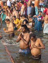 People perform ritual bath and puja prayers at ghats in the River Ganges