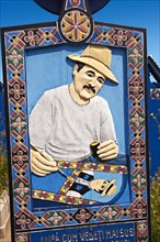 Tombstone showing a man painting the tombstones