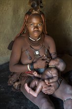 Himba woman breast feeding her baby