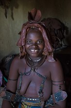 Himba woman sitting in her hut