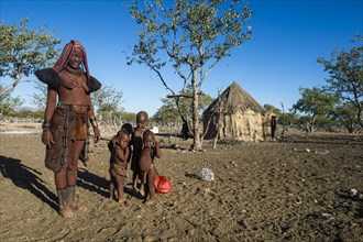Himba woman with her children in village
