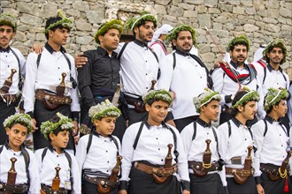 Traditional dressed children and men with with crooked dagger