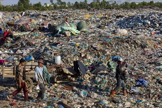 Garbage collector in garbage dump with plastic garbage