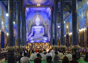 Believers in front of the Blue Buddha Statue of Wat Rong Seur Ten