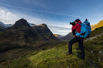Photographer in mountain landscape with peaks of Stob Coire nan Lochan