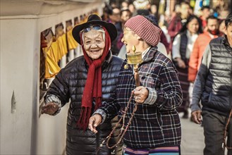 Laughing Tibetan women with prayer wheel