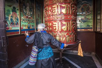Buddhist turns to prayer wheel
