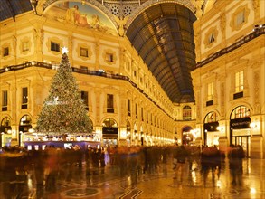 People marvel at Christmas tree and Christmas lights in luxury shopping arcade