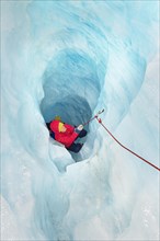 Rock climber moving up ice cave