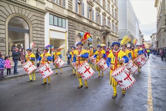 Drummer in historical costume marching through street