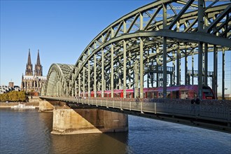 Cologne Cathedral with regional train on the Hohenzollern Bridge and the Rhine River
