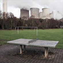Dreary playground in the Auenheim district in front of the steaming lignite-fired power plant Niederaussem