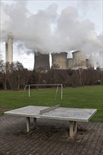 Dreary playground in the Auenheim district in front of the steaming lignite-fired power plant Niederaussem