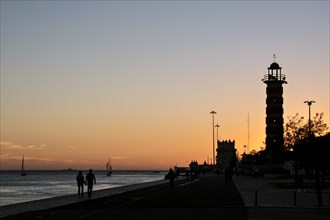 Sunset at the Rio Tejo with lighthouse and tower Torre de Belem