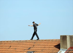 Chimney sweep balances on the roof