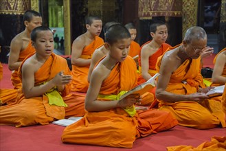 Buddhist monks praying in the temple Wat Xieng Thong