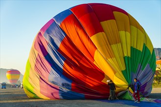 Colourful hot air balloon on ground after landing