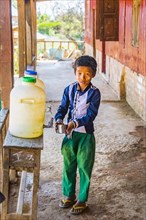 Young boy filling his cup with drinking water