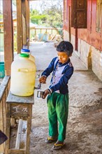 Young boy filling his cup with drinking water