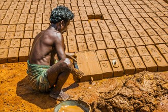 Indian man making clay bricks