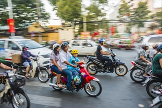 Family on a scooter in heavy traffic