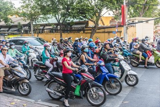 Crowd of scooter riders waiting at traffic light
