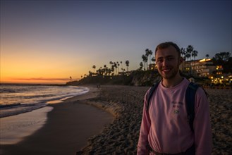 Young man at the beach at sunset