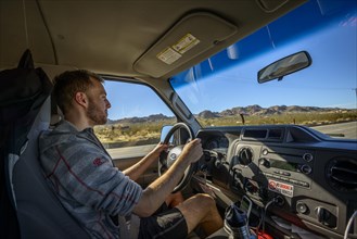 Young man driving a car in a camper van