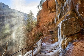 Waterfall falling from overhanging rock in winter