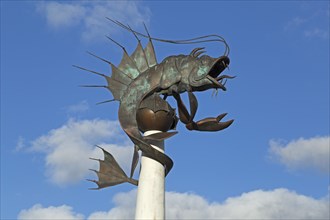 Fish sculpture with cloudy sky