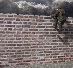 Man climbing over a wall
