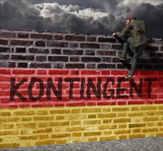 Man climbing over a wall with writing contingent and German flag