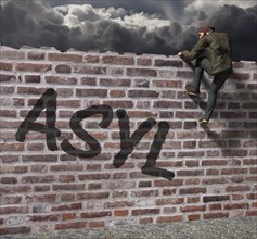 Man climbing over a wall with writing asylum