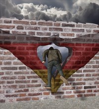 Man climbs through Merkel diamond on a wall with German flag