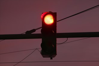 Traffic light shows red at dusk