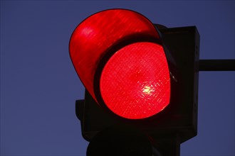 Traffic light shows red at dusk