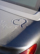 Iced vehicle in winter with painted heart