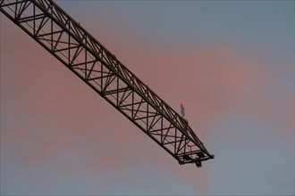 Illuminated crane boom on a construction site