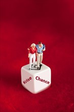 Pair of figures stands on cube with stroke crisis or chance